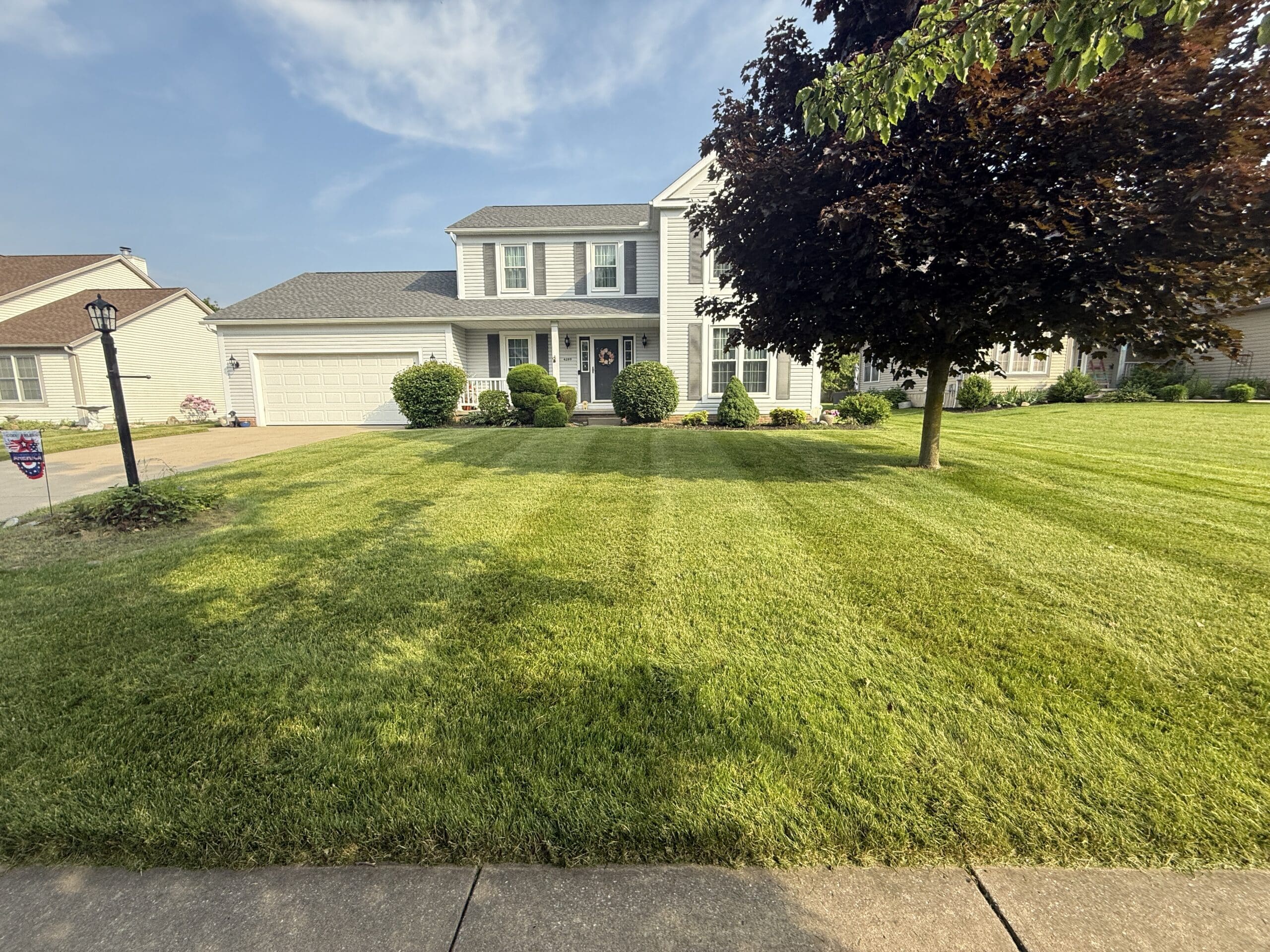 A home with a large front lawn has a radiant trim, looking clean, crisp, and neat.