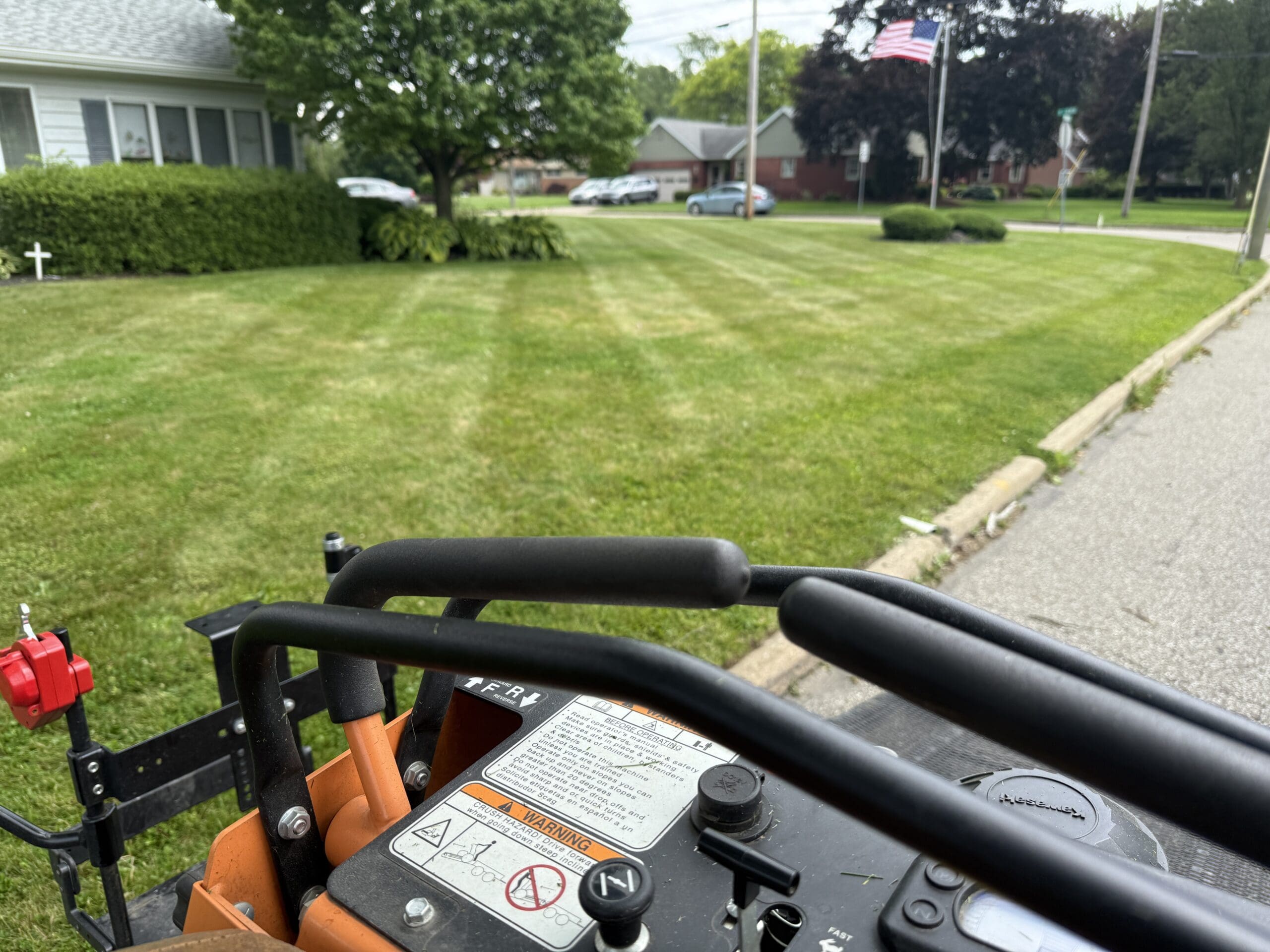 The image shows the side of a lawn, freshly mowed by Pro Finish Lawn Care